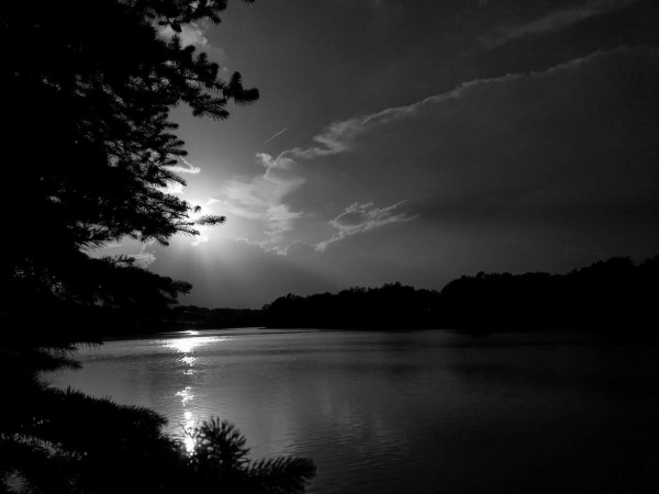 A black and white photo of a sunset over a lake